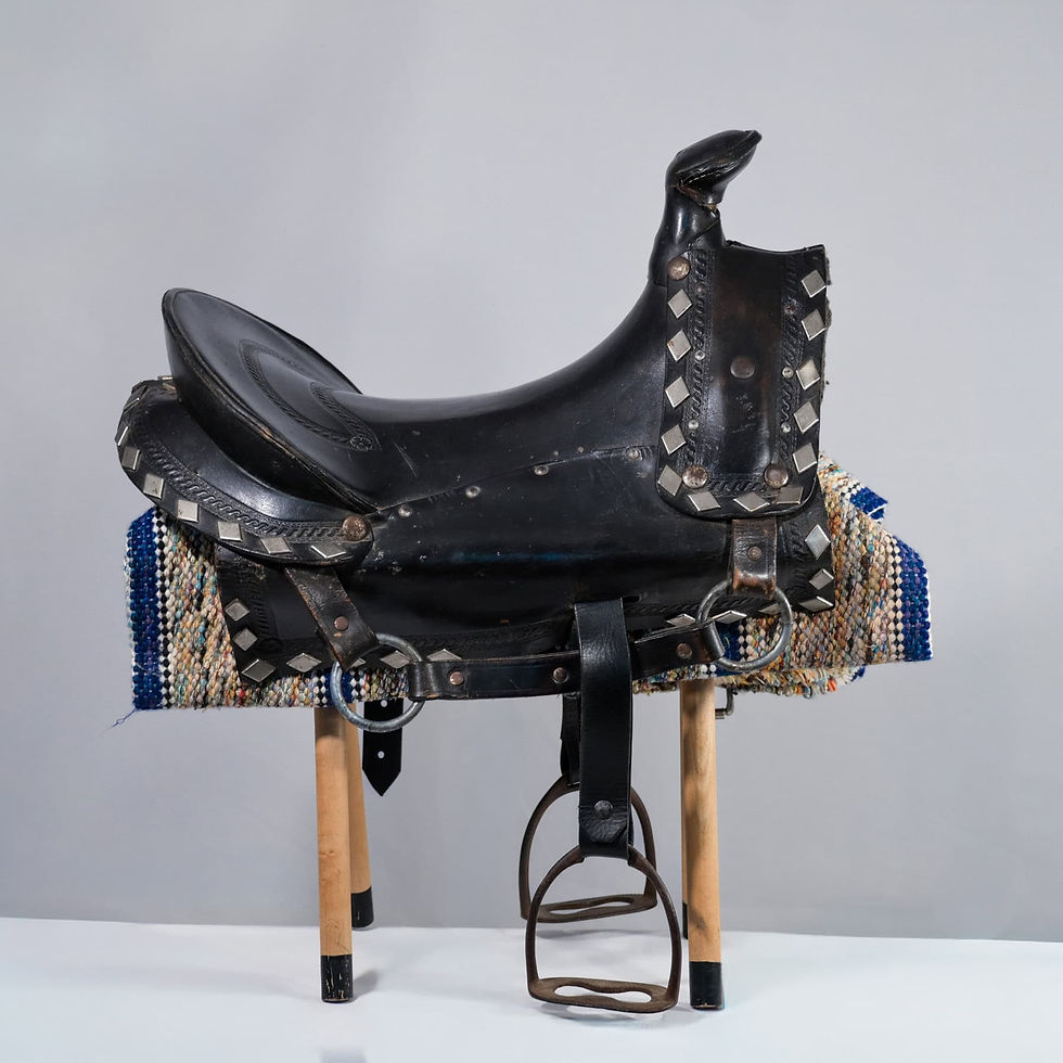 Vintage child-sized black leather western saddle featuring silver diamond conchos and tooled leather accents.