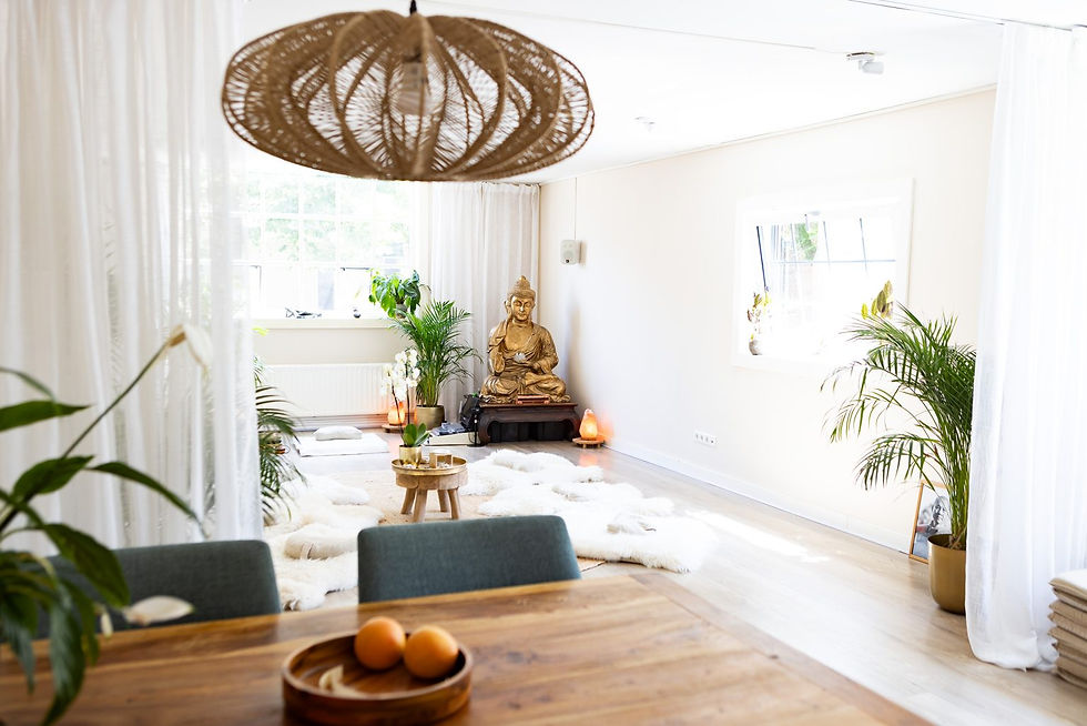 Lichte meditatiekamer met gouden Boeddhabeeld, planten, witte vachtkleed en houten tafel; serene, rustgevende sfeer.