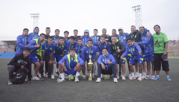 Equipo de fútbol celebrando victoria con trofeo