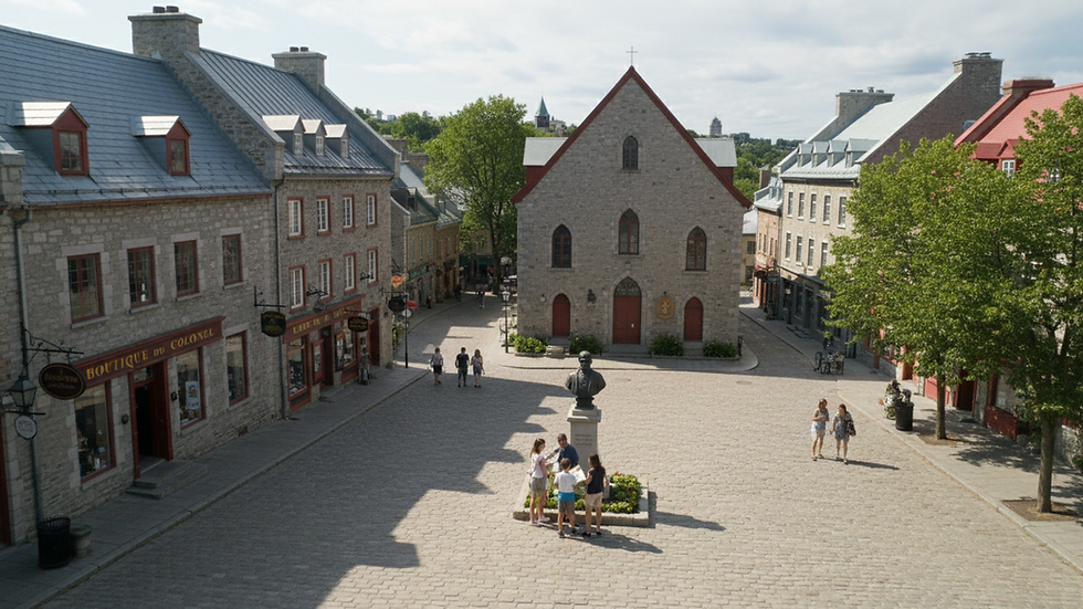 Vue en plongée d’une famille visitant la Place Royale à Québec