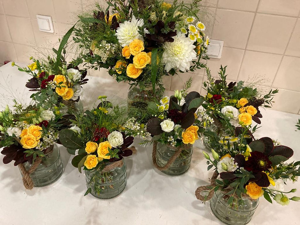 Ensemble de bouquets de saison coordonnés pour une soirée d'entreprise, mêlant roses, feuillages et