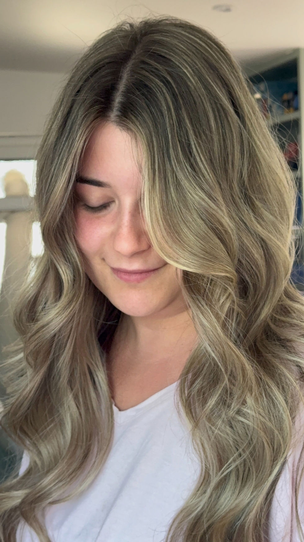 Woman with a lived-in blonde hairstyle and soft waves.