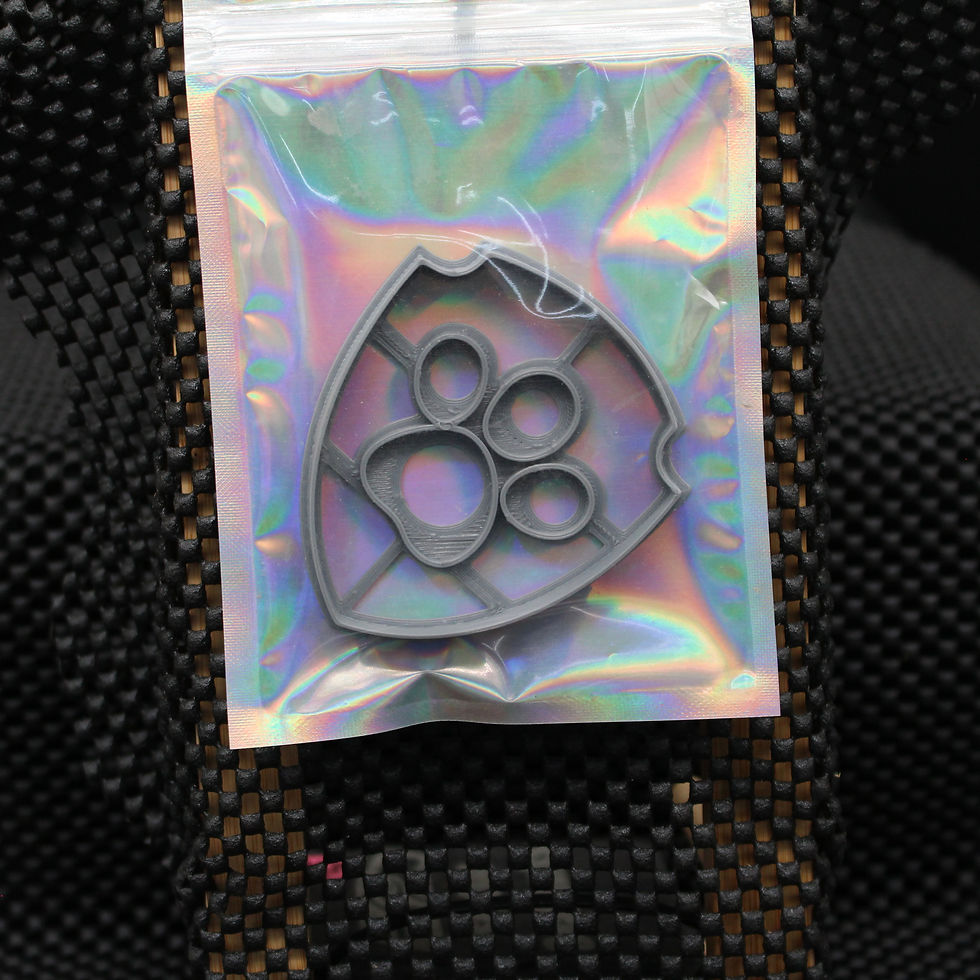 Paw print shaped cookie cutter in a holographic bag. SpellBound LaserCraft LLC