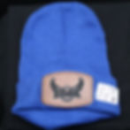 Thumbnail: Blue beanie with eagle logo and product tag on a black surface.