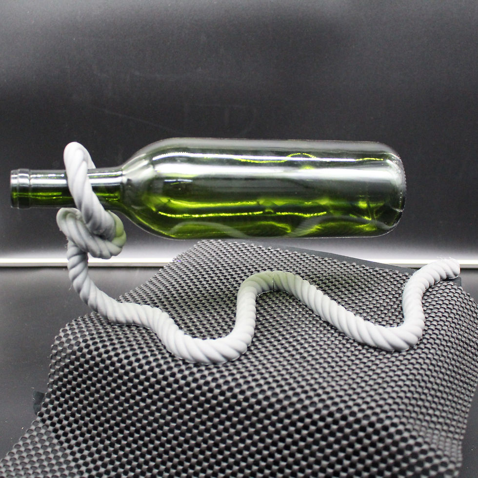 Green wine bottle resting on a white rope with a checkerboard background.