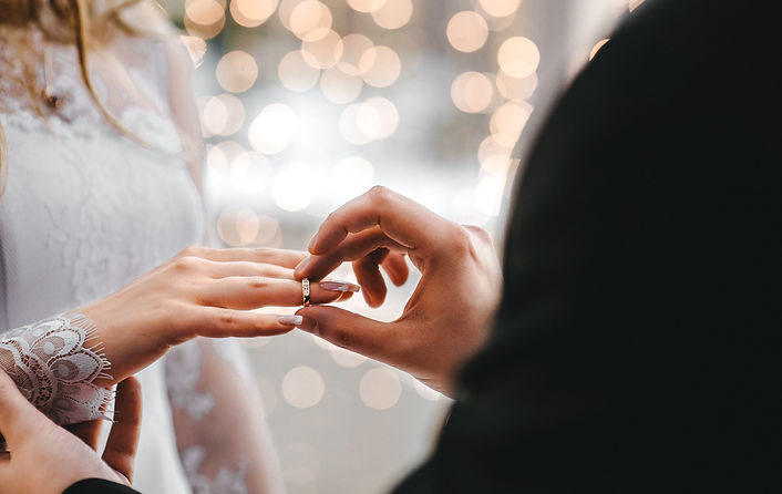 Groom putting the wedding ring on the bride at the wedding ceremony.