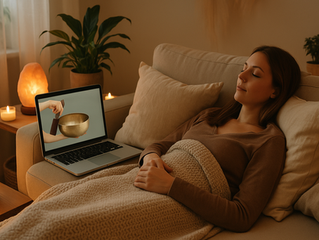 A woman receiving sound healing remotely, lying comfortably next to her laptop.