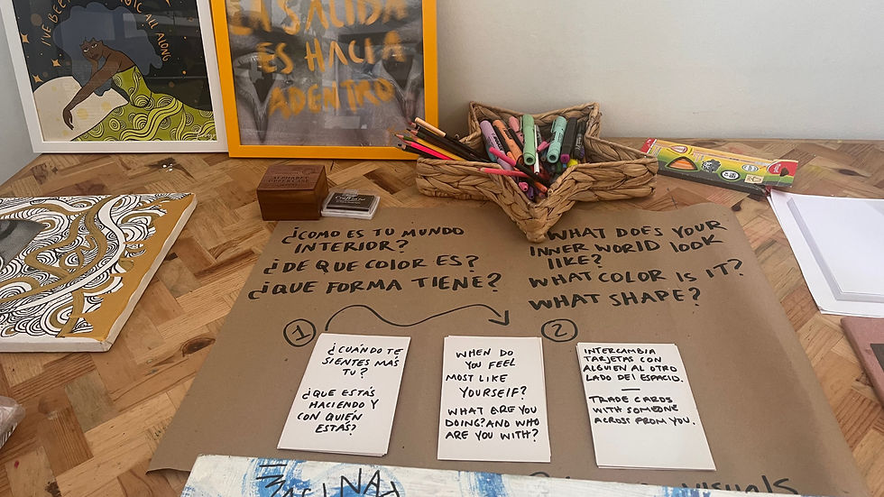 Mesa creativa en Mairels Bookshop con tarjetas de preguntas, marcadores, obras y mensajes escritos a mano en español e inglés que invitan a reflexionar sobre nuestros mundos internos durante una experiencia colectiva de descanso guiada por Yurani en Mairels Bookshop.