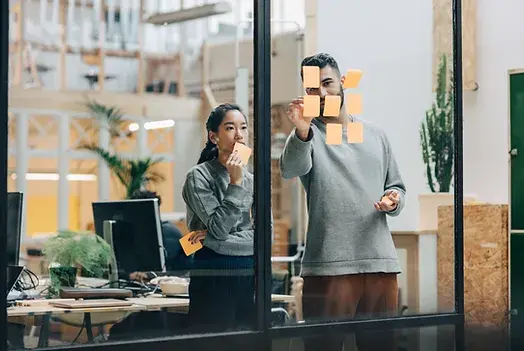 Equipo creativo planeando ideas con notas adhesivas en una oficina moderna.