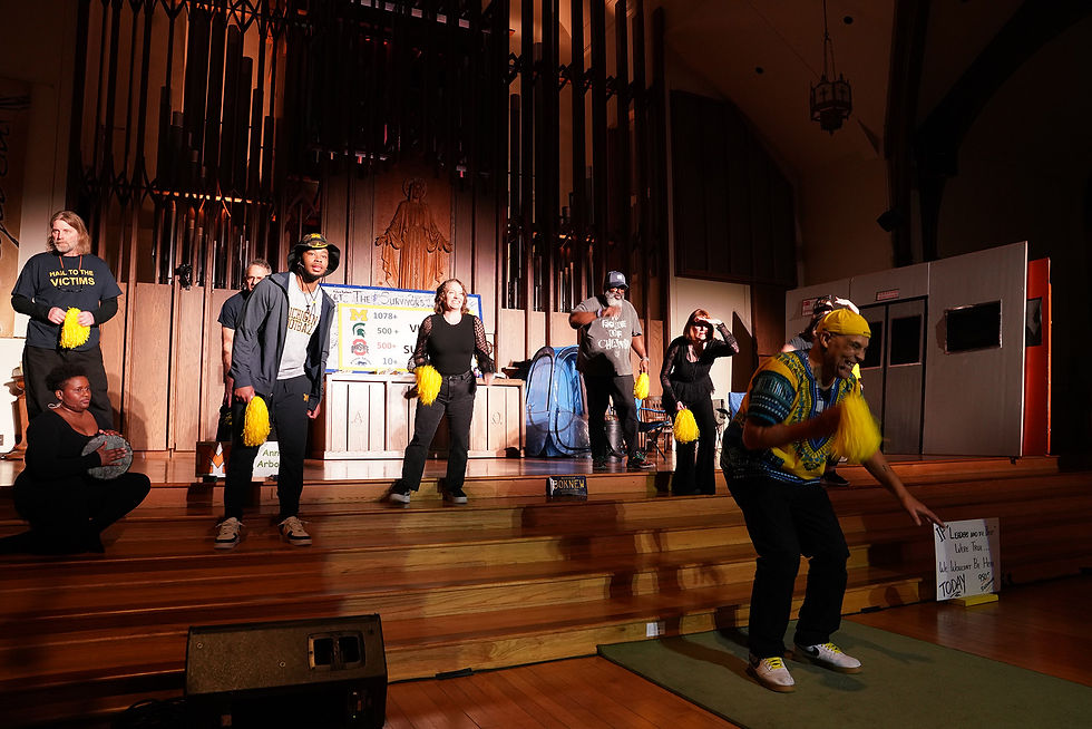 Escena de “This Doesn’t Happen at Michigan”, parte de la producción musical, teatral y de danza Ni une más. Intérpretes sostienen pompones amarillos sobre un escenario iluminado dentro de una capilla, expresando fuerza y solidaridad. Un cartel al fondo honra a las sobrevivientes. Foto de Mark Clague, marzo de 2024.