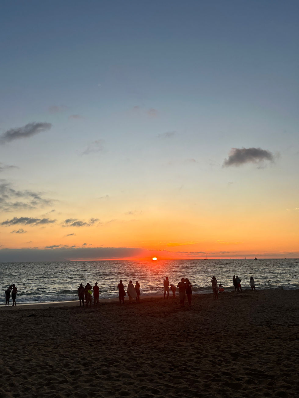 Silhouettes of family and community witness the sunset in Puerto Vallarta, where the ocean and fading light invite reflection, connection, and shared stillness.