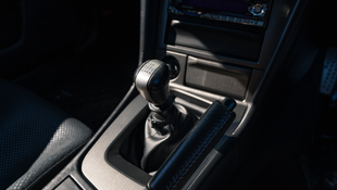 web-16x9_listing-images_Nissan-BNR34-VSpecII-White0028-interior-center-console-shifter.png