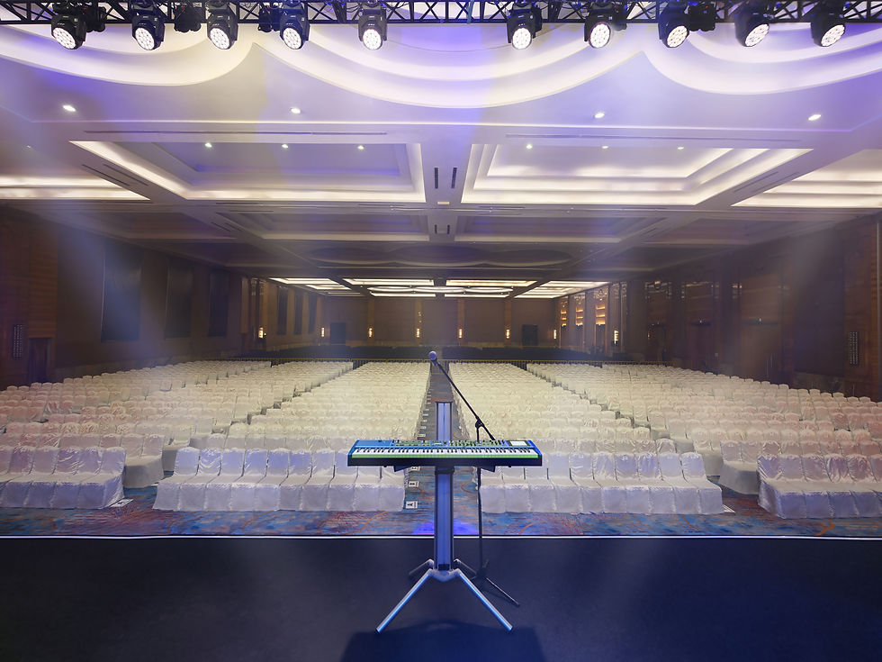Pullman Grand Ballroom arranged for a concert with a stage, audience seating, and professional event lighting.
