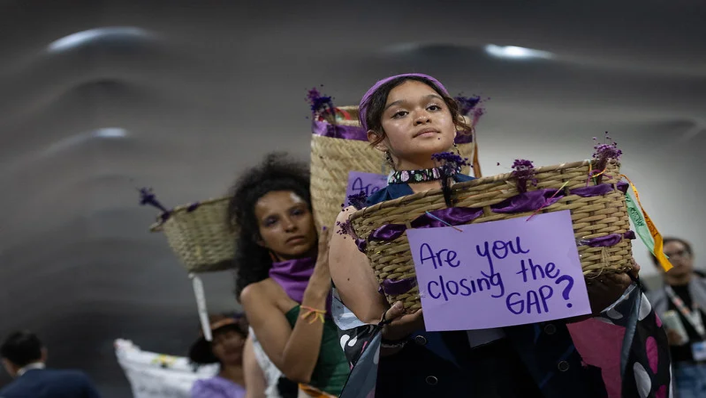 2 women holding baskets with a sign asking 'are you closing the gap?'