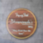 Round wooden nameplate with golden rim, featuring welcome message in Arabic and personalized name.