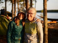 Zwei lachende Teilnehmende blicken glücklich in die Kamera – gemeinsames Erleben auf geführter Kajaktour im Saimaa-Seengebiet in Finnland