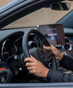 Experienced professional driver confidently holding the steering wheel in the luxurious Mercedes-Benz V-Class interior, ready for a premium long-distance private transfer across Europe by MYEUTAXI