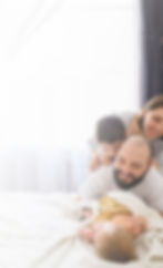 Happy family with three children on bed