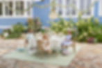 Three children sat at a table outdoors at a Peter Rabbit themed party for Pottery Barn.