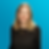 Danielle Tanton wearing a black shirt is posing in front of a blue background