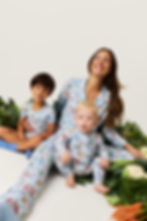 A woman holding two young children, all wearing the clothes from the Peter Rabbit Posh Peanut collection