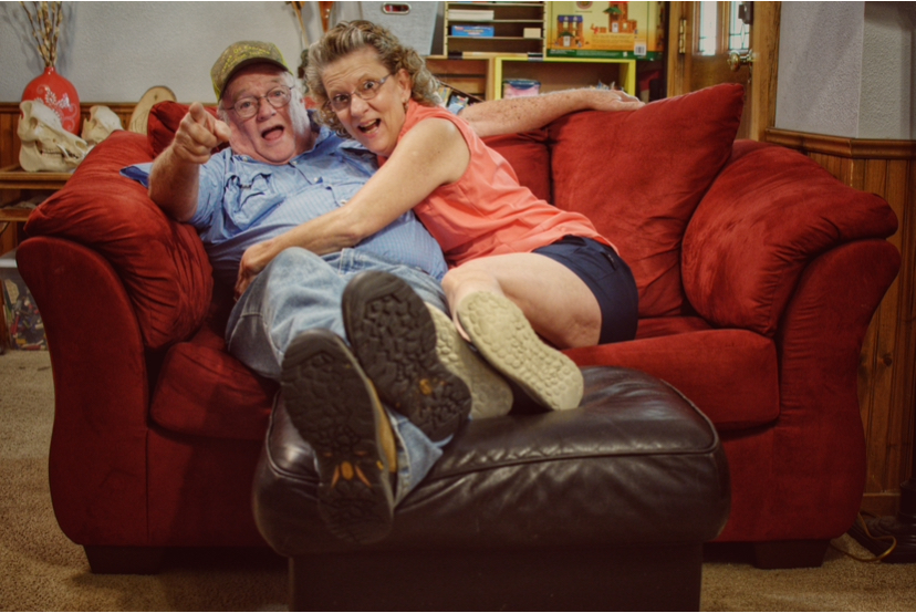 Sandy & Cheryl Dozier laughing and hugging on a couch together