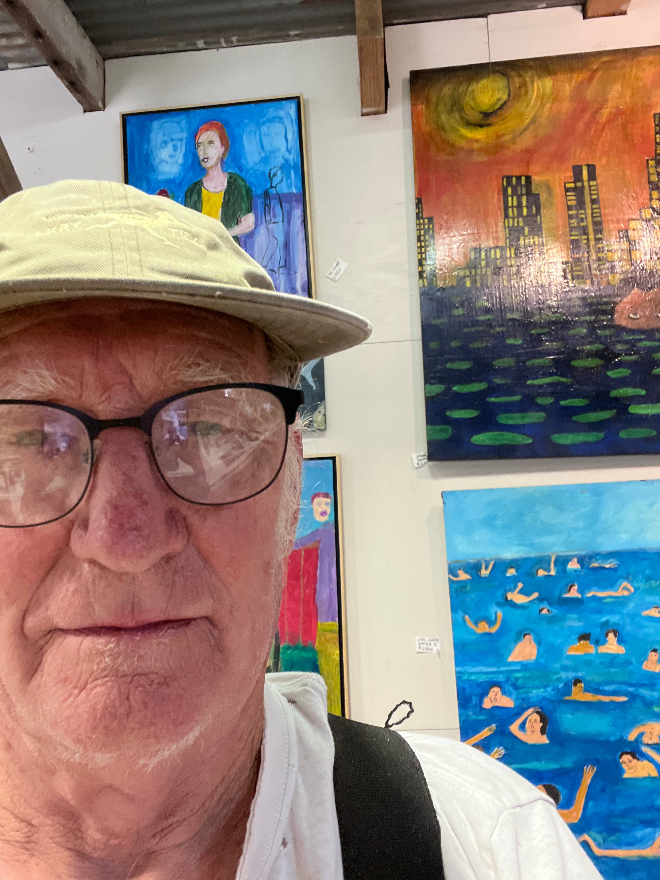 Ralph Fulton standing in front of wall of paintings