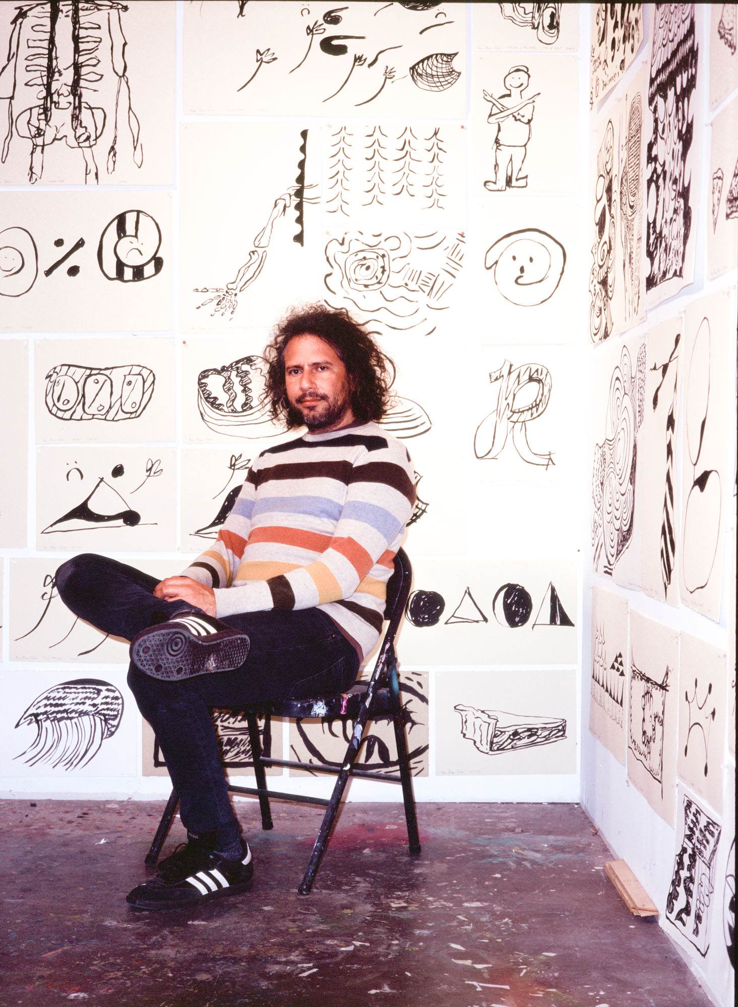 Ryan Thayer Davis in front of white wall with lots of drawings in black