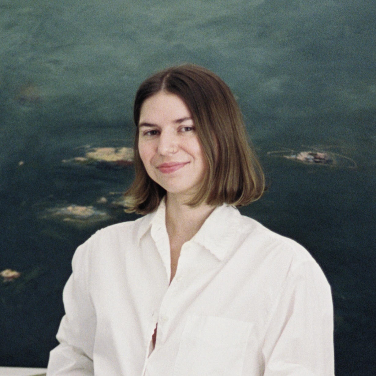 Taryn Wenske standing in front of grey green painting