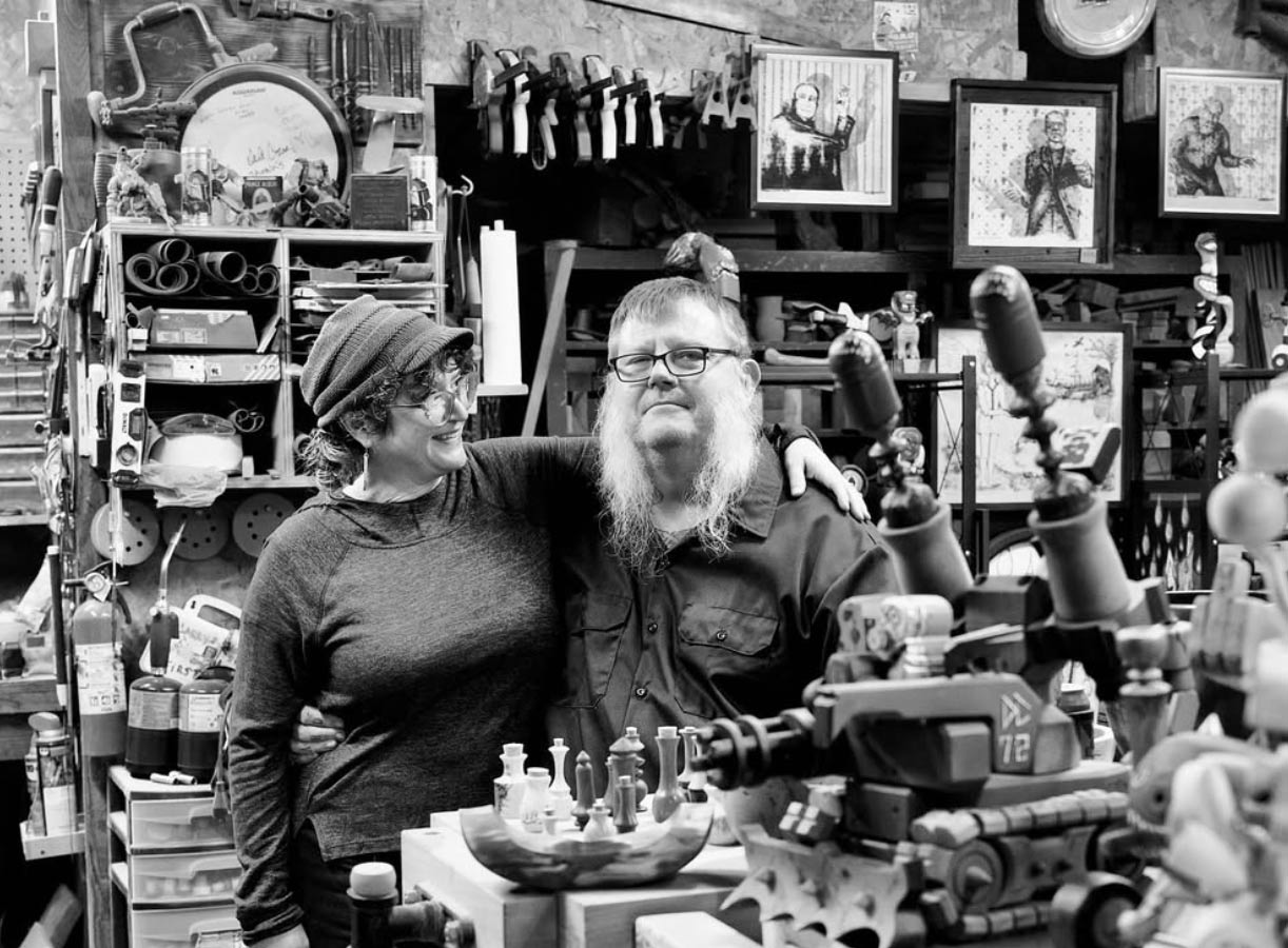 Sarah and Terry with arms entwined in wood shop 