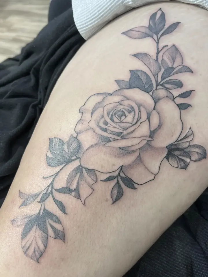 Fine line black and grey floral tattoo on a female