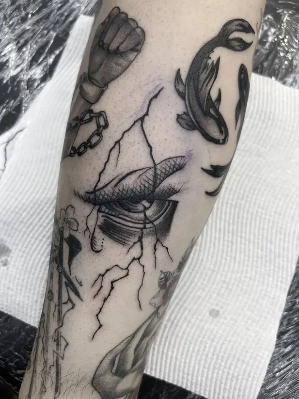 Sinister eye with lightning striking tattoo on man's arm
