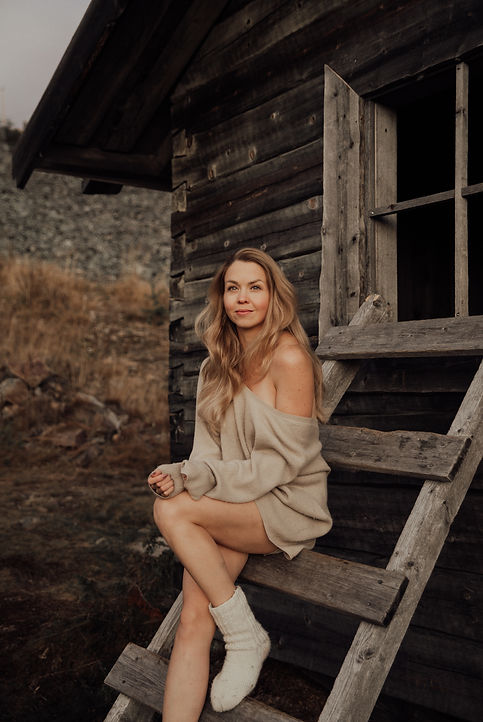 Boudoir kuvassa Levitunturilta vaalea nainen istuu Joulupukin mökin ulkoseinään nojaavilla tikapuilla. Nainen hymyilee ja näyttää valtavan onnelliselta katsoessaan auringonlaskuun kohti Levin keskustaa. Naisen vasen jalka on koukussa alemmalla portaalla. Naisella on yllään beige, iso ja löysä neule. Jalassaan naisella on valkoiset villasukat.