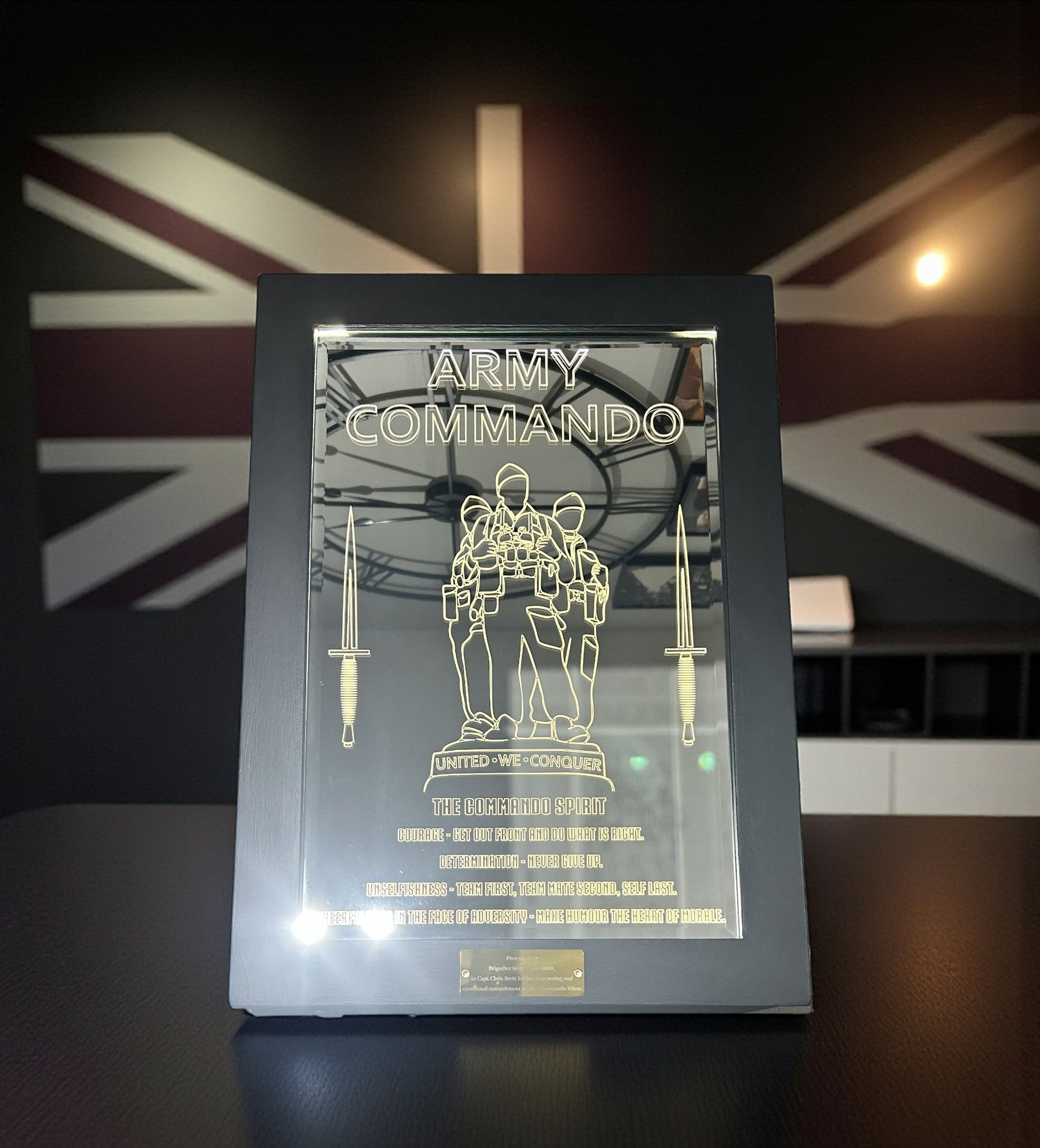 Engraved plaque featuring soldiers, text, and clock design on a Union Jack background.