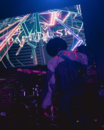 Photography of the guitarist from the Japanese band Paledusk playing guitar on stage.