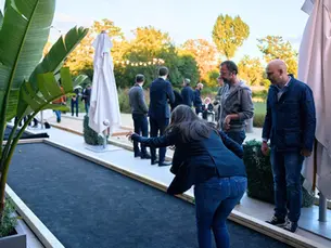Une femme qui tire à la pétanque sur un terrain éphémère