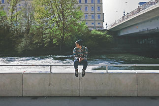 Guy sitting on bridge