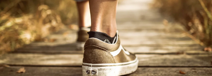 Feet taking a step forward on a path