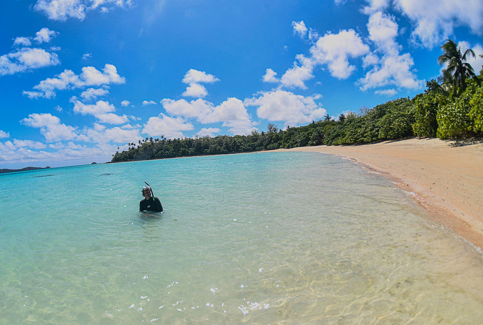 Thumbnail: a person enters the warm blue lagoon from the beach