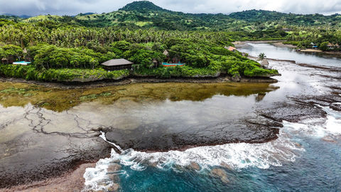 Aerial view of a tropical island with lush greenery and clear waters conservation
