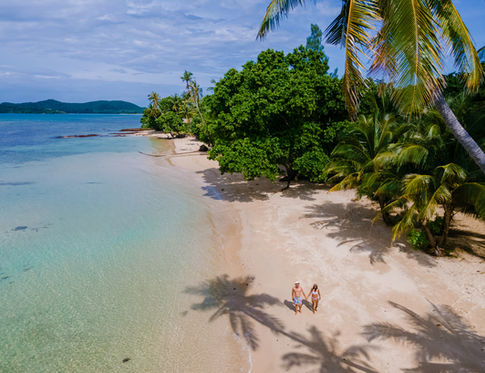 Couple walks on pristine Taveuni beach
