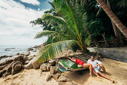 Couple relaxing on tropical beach near boat