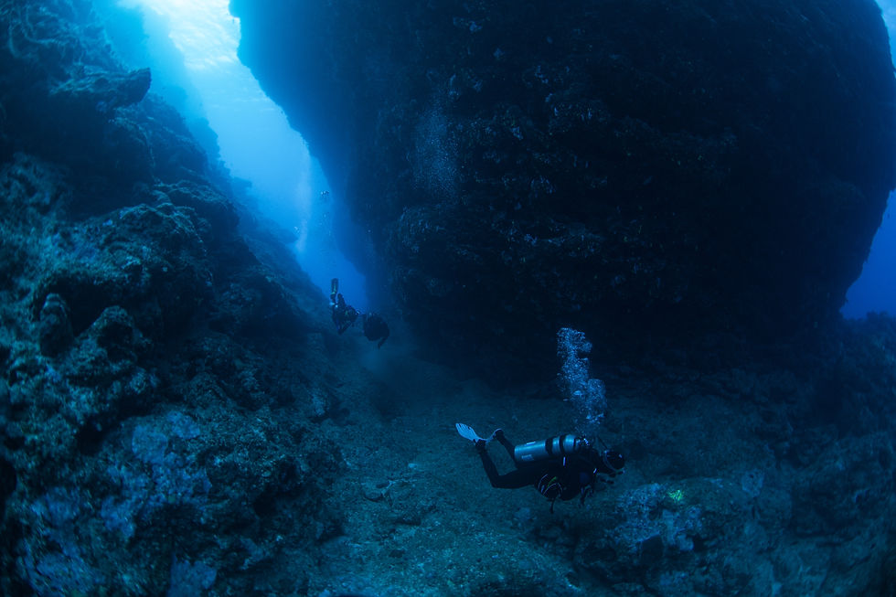 Thumbnail: Divers swim through an ocean cavern in Fiji