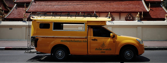 Yellow truck parked in front of a temple