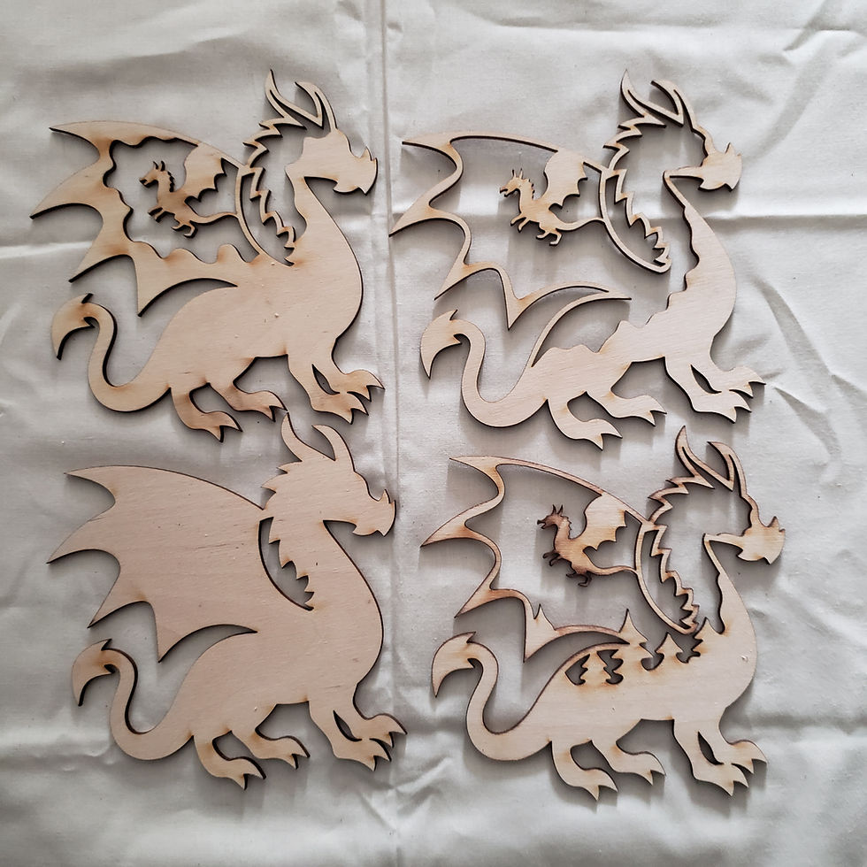 Thumbnail: Wooden dragon cutouts on a white surface, Dragons Layered, for crafting projects.