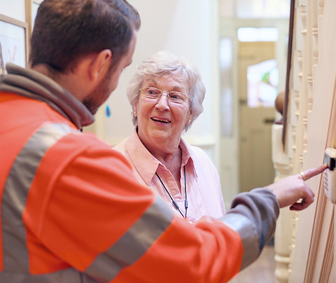 an alarm fitter demonstrates to a senior woman in her home how to set the alarm_edited.jpg