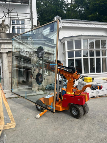 a large window being carried by a machine