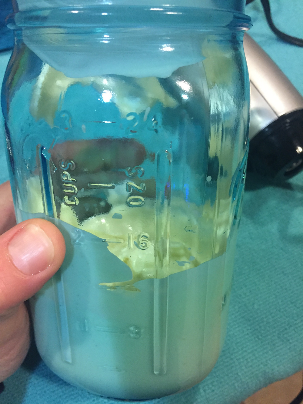 Hand holding mason jar with avocado mayonnaise
