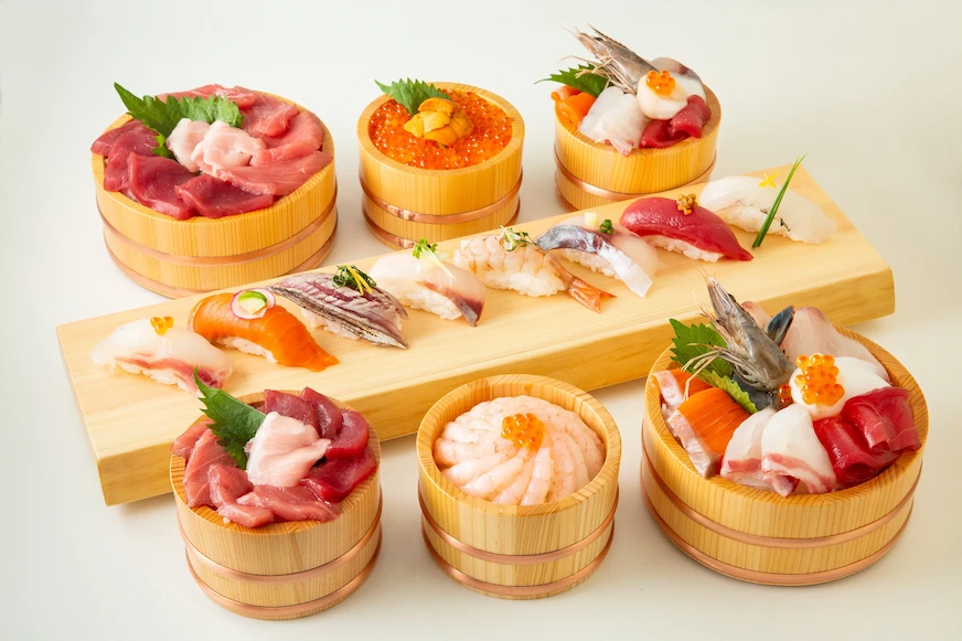 咖啡色木托盤上擺放多種鮮豔壽司和生魚片料理