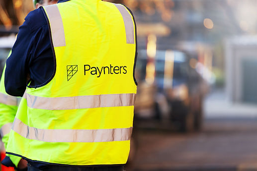 Back view of Paynters staff member wearing branded hi vis safety vest on site